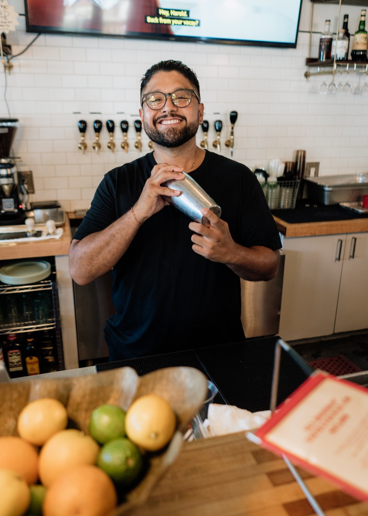 Armando behind the bar, smiling and holding a cocktail shaker