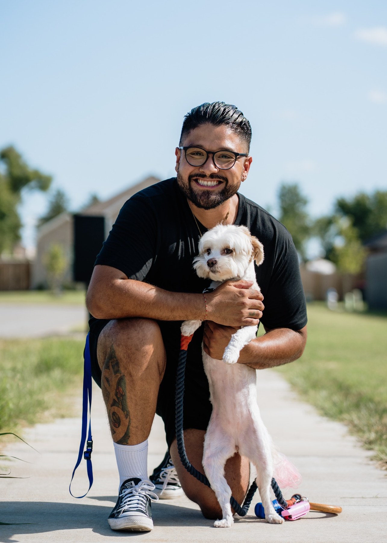 Armando smiling outdoors with a dog
